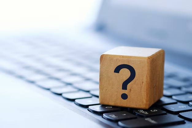 Wooden cube with question mark on laptop keyboard