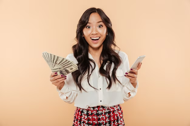 Woman holding cash and smartphone